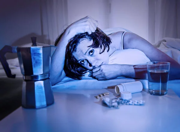 Depressed woman in bed suffering hangover after party night having water coffee and tablets — Stock Photo, Image