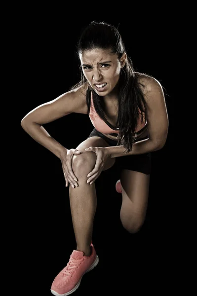 Sport woman holding injured knee suffering pain in ligaments in — Stock Photo, Image