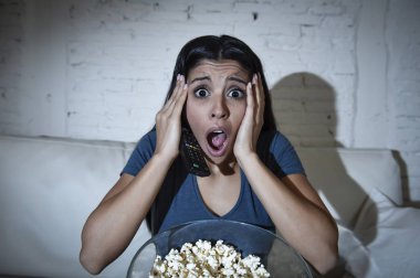  latin kadın evde koltuk kanepe oturma odasında televizyon korkunç korku filmi izlerken oturuyordu