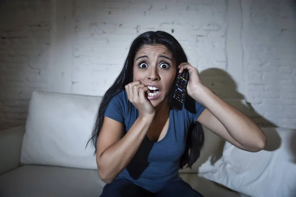 Femme latine à la maison canapé canapé dans le salon regarder la télévision film d'horreur effrayant ou suspense thriller — Photo