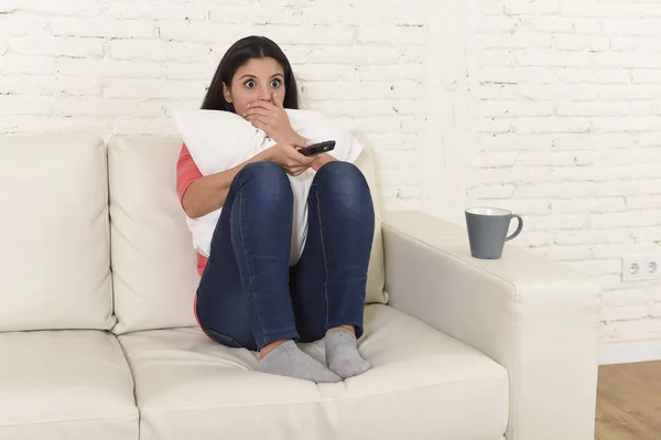 Latina mulher sentado em casa sofá sofá na sala de estar assistindo televisão assustador filme de terror — Fotografia de Stock