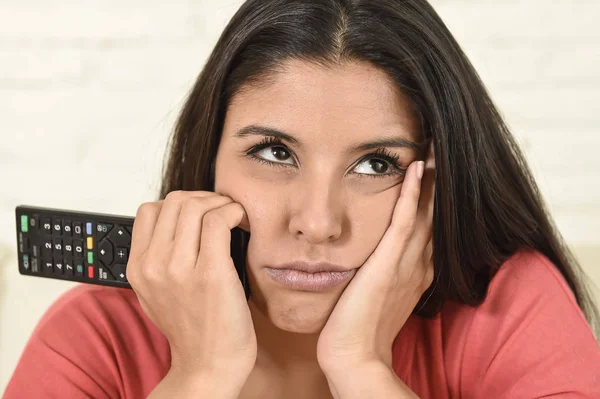 Jeune belle hispanique femme à la maison regarder la télévision fatigué et ennuyé — Photo