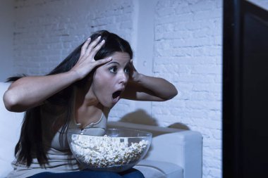 Latin kadın ev koltuk kanepe oturma odasında televizyon korkunç korku film ya da Gerilim Gerilim izlerken