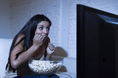 Latin kadın ev koltuk kanepe oturma odasında televizyon korkunç korku film ya da Gerilim Gerilim izlerken