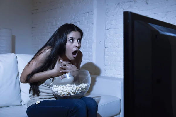 Latijnse vrouw in huis banklaag in woonkamer kijken televisie enge horror film of suspense thriller — Stockfoto