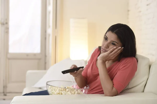 Молода красива жінка вдома дивиться телевізор втомлений і нудний — стокове фото