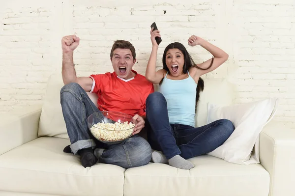 Joven pareja viendo tv deporte fútbol partido emocionado celebrando — Foto de Stock