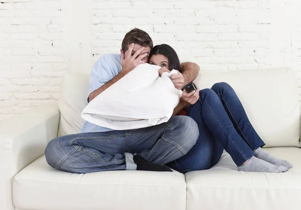 Ελκυστικό ζευγάρι που έχοντας διασκέδαση στο σπίτι απολαμβάνοντας βλέποντας τηλεόραση δείχνουν ταινία τρόμου — Φωτογραφία Αρχείου