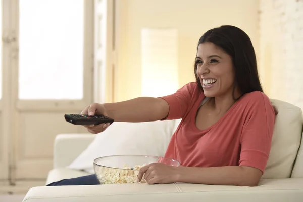 Jolie femme latine à la maison canapé canapé rire et sourire heureux regarder la télévision — Photo