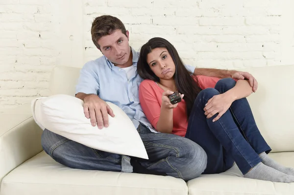 Пара смотрит телевизор вместе на диване дома диван выглядит скучно разочарованные переключения каналов — стоковое фото