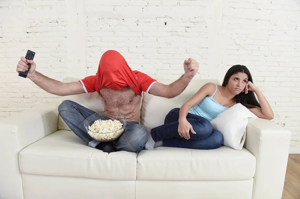 Coppia guardando tv sport calcio con l'uomo eccitato celebrando folle felice obiettivo e donna annoiata — Foto Stock