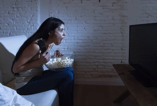 Šťastná žena, dívat se na televizi na rozkládací pohovce šťastný vzrušený, těší jíst popcorn — Stock fotografie