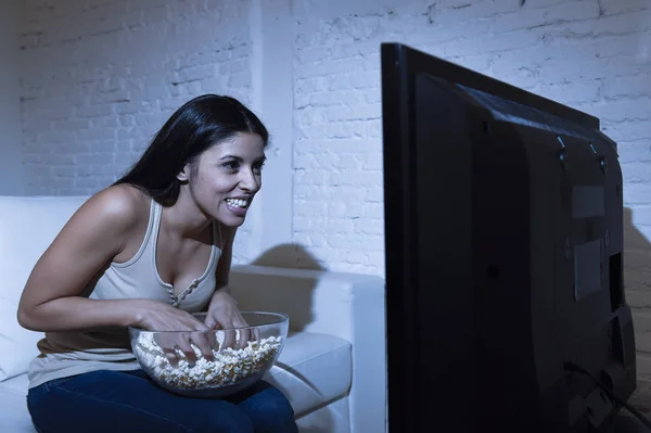 Wanita bahagia menonton televisi di sofa senang senang menikmati makan popcorn — Stok Foto