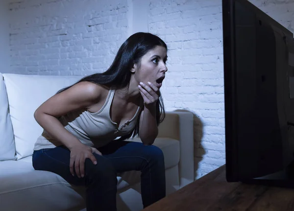 Латинська жінка вдома дивиться телевізор близька відстань збуджена концепцією залежності від телебачення — стокове фото