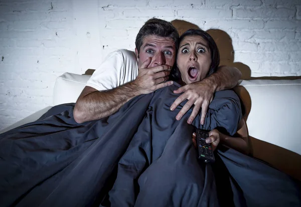 Attraente coppia a casa godendo guardando televisione horror film copertura con coperta — Foto Stock