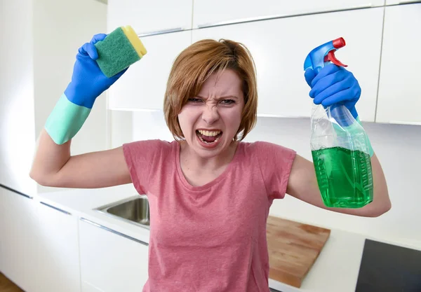 Жінка на домашній кухні в рукавичках тримає прибиральник і миючий розпилювач пляшка кричить — стокове фото