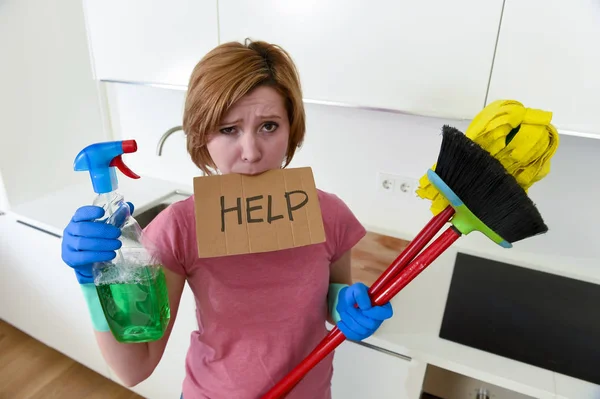 Woman at home kitchen in gloves with cleaning broom and mop asking for help — Stock Photo, Image