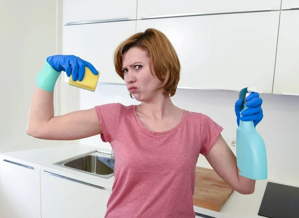 Femme aux cheveux roux dans des gants de lavage en caoutchouc tenant bouteille de pulvérisation de nettoyage et scourer — Photo