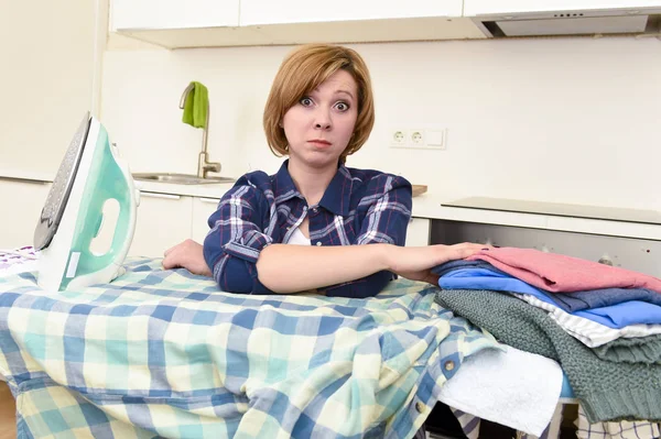 Traurige Frau oder geschäftige Hausfrau, die in der heimischen Küche faul Hemd bügelt — Stockfoto