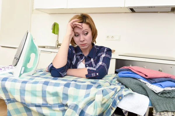 Traurige Frau oder geschäftige Hausfrau, die in der heimischen Küche faul Hemd bügelt — Stockfoto