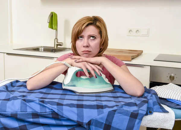 Treurige vrouw of drukke huisvrouw strijken shirt lui bij u thuis keuken — Stockfoto