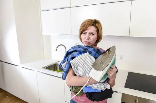 Traurige Frau oder geschäftige Hausfrau, die in der heimischen Küche faul Hemd bügelt — Stockfoto