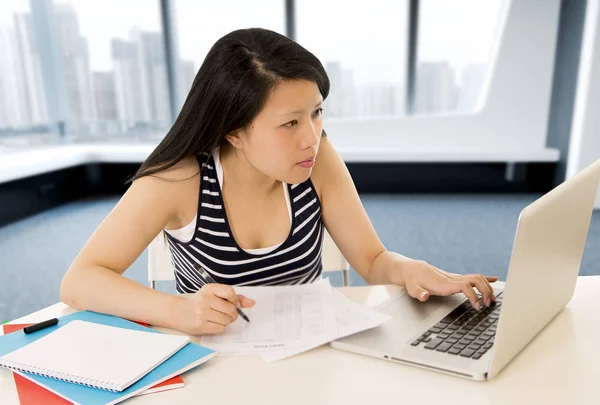 Chinesische Asiatin arbeitet und studiert auf ihrem Laptop am modernen Bürocomputer-Schreibtisch — Stockfoto