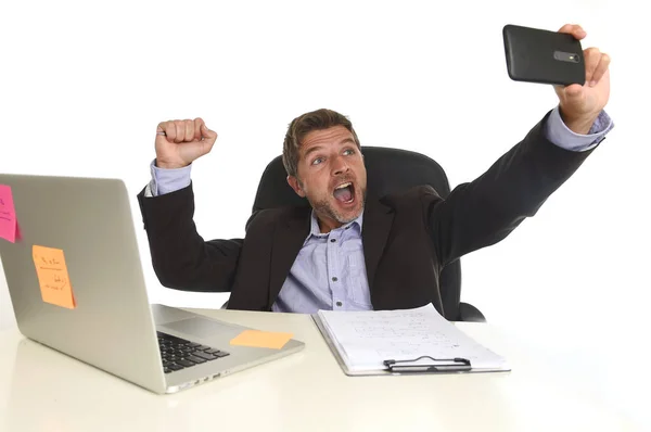 Hombre de negocios en traje que trabaja en escritorio de la computadora portátil de la oficina usando el teléfono móvil para tomar la foto del selfie — Foto de Stock