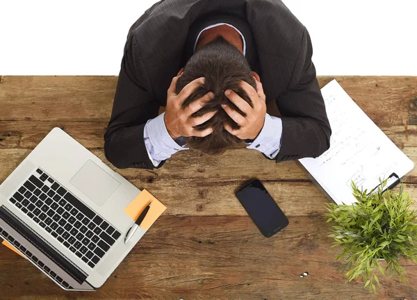 Geschäftsmann sitzt mit den Händen auf dem Kopf am Schreibtisch und weint am Boden zerstört und frustriert — Stockfoto