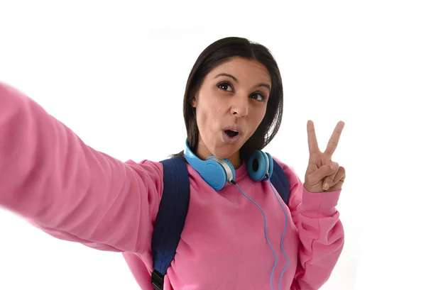 Attractive and happy woman or student girl with backpack and headphones taking selfie photo — Stock Photo, Image