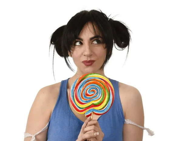 Sexy mujer con coletas mordiendo sus labios sosteniendo y lamiendo dulce caramelo grande lollipop — Foto de Stock