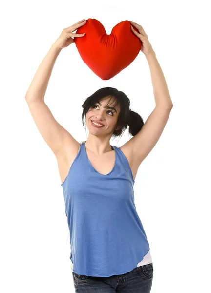 Bella donna sorridente sensazione felice in amore tenendo cuscino rosso a forma di cuore — Foto Stock