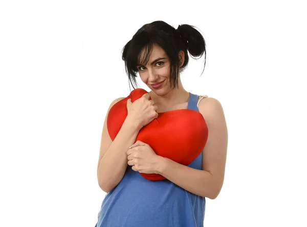 Aantrekkelijke en mooie vrouw die lacht tevreden gevoel in liefde met rood hart vorm kussen — Stockfoto