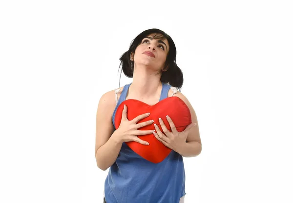 Mooie vrouw die lacht tevreden gevoel in liefde met rood hart vorm kussen — Stockfoto