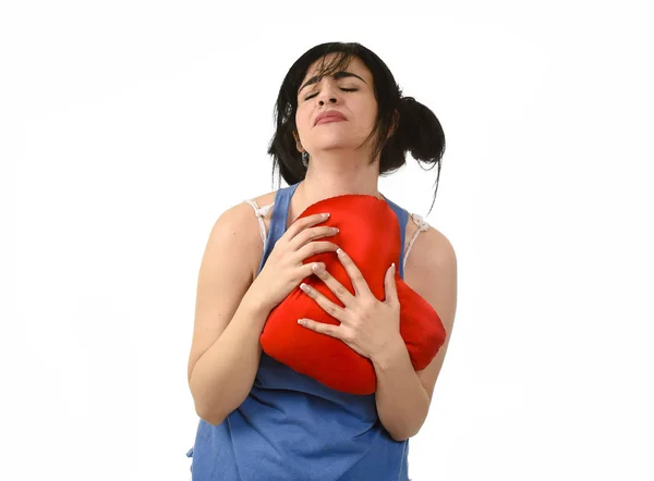 Hermosa mujer herida y sufriendo por el amor perdido sosteniendo almohada en forma de corazón rojo —  Fotos de Stock