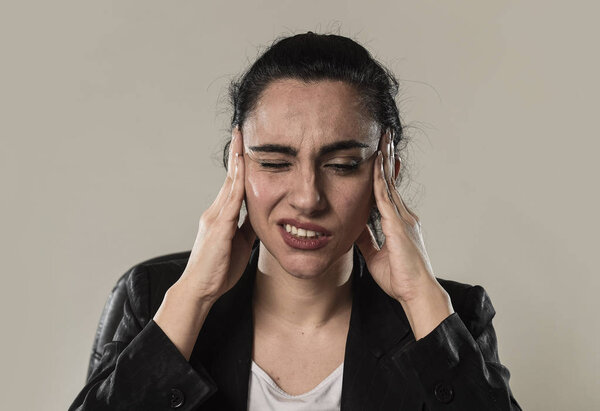 business woman in office suit suffering migraine pain and strong headache
