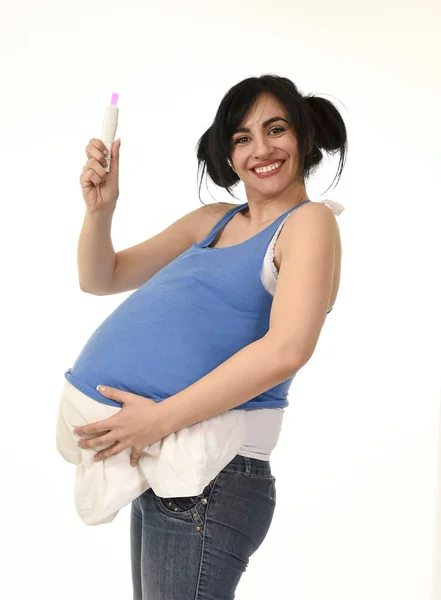 Mulher grávida com travesseiro na barriga mostrando resultado positivo rosa no teste de gravidez — Fotografia de Stock