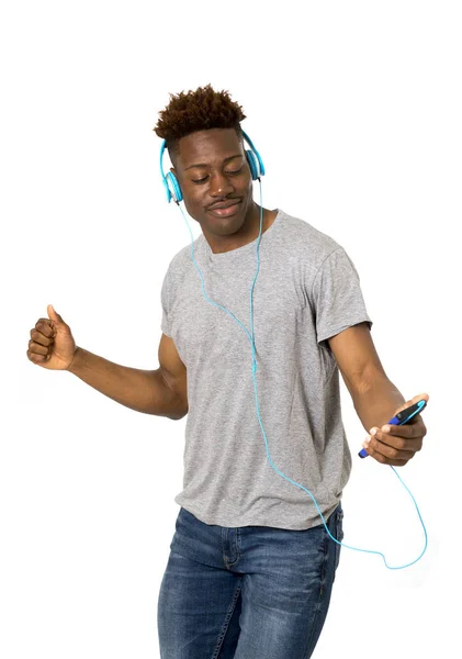 Ο άνθρωπος του μαύρο μαθητή με ακουστικά και ακούγοντας μουσική, χορεύουν και τραγουδούν το κινητό τηλέφωνο — Φωτογραφία Αρχείου