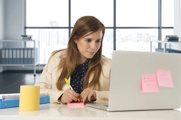 Atractiva mujer sentada en la silla de oficina trabajando en el escritorio del ordenador portátil — Foto de Stock