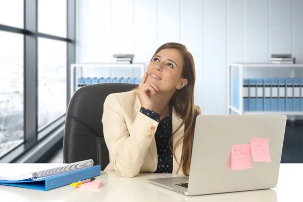 Žena na úřadu práce v přenosný počítač stůl s úsměvem šťastný promyšlené a zamyšlený — Stock fotografie