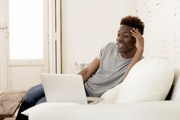 Gelukkig zwarte man banklaag werken of genieten van internet film in laptop om thuis te zitten — Stockfoto