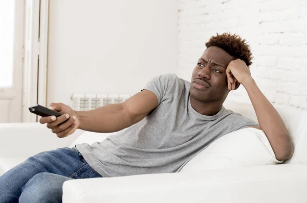 坐在家里的沙发沙发上看电视的吸引力黑色非洲裔美国人 — 图库照片