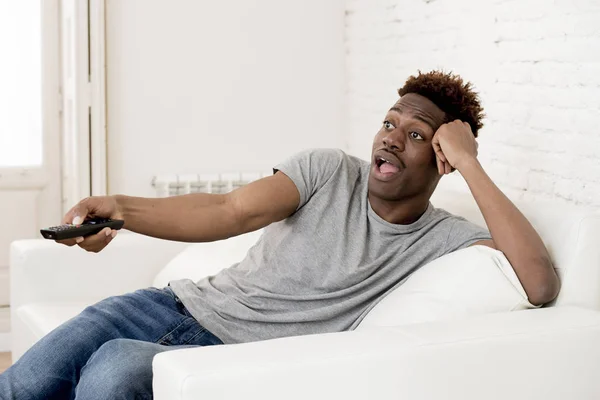 Atractivo negro africano americano hombre sentado en casa sofá sofá viendo televisión — Foto de Stock