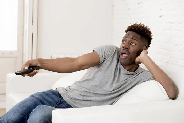 Atractivo negro africano americano hombre sentado en casa sofá sofá viendo televisión — Foto de Stock