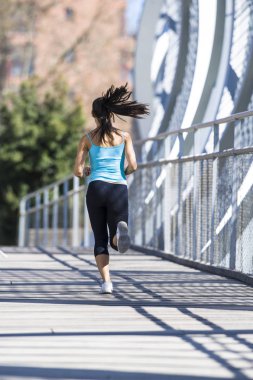 çalışan ve modern metal şehir köprüyü geçtikten koşu genç güzel atletik spor kadın