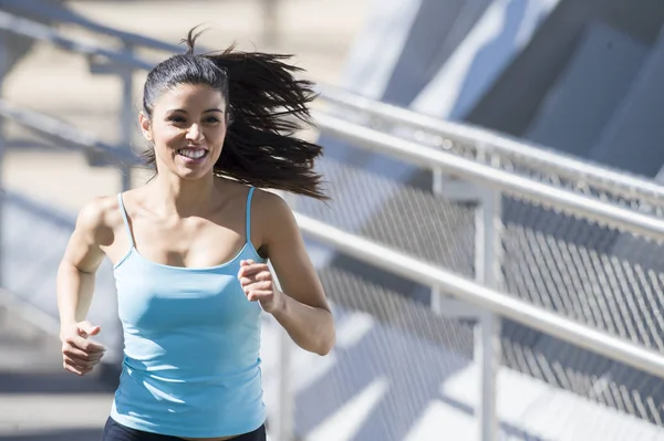 Junge schöne athletische Sportlerin läuft und joggt über moderne metallene Stadtbrücke — Stockfoto