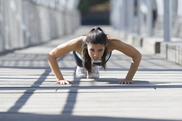 athletic sport woman doing push up before running in urban training workout