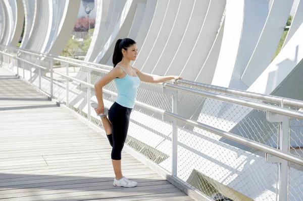 Joven hermosa atlética deporte mujer estiramiento después de correr cruzar moderno metal puente de la ciudad — Foto de Stock