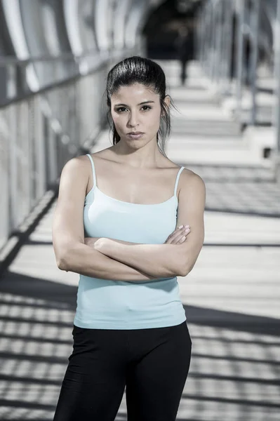 Attractive hispanic brunette woman looking cool and defiant after running workout — Stock Photo, Image