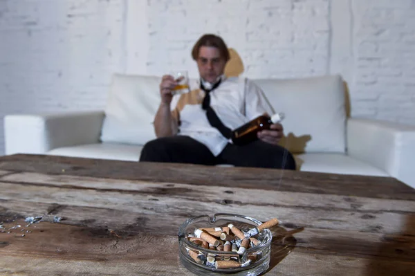 Detailní záběr popelník nedopalků a smutné depresivní alkoholické podnikatel zbytečná a opilá — Stock fotografie